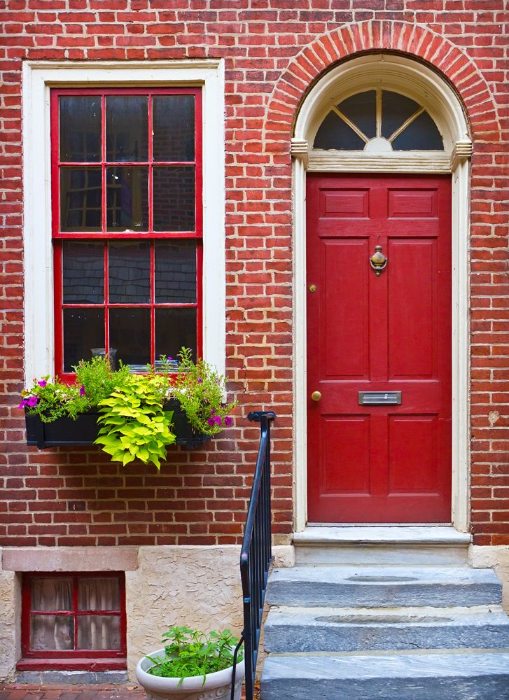 brick building with red entry door and white trim
