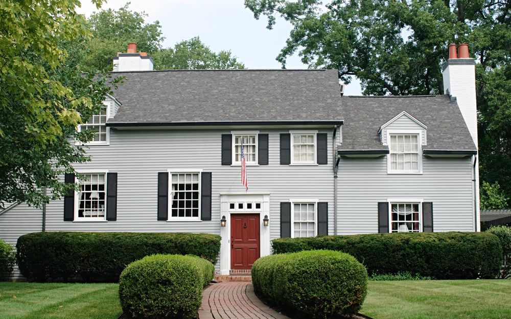 light gray home with black shutters and red door