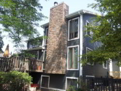 This is a beautiful example of using Versetta Stone siding paired with James Hardie fiber cement siding. We installed Versetta Ledgestone veneer on the chimney and HardiePlank lap siding in "Iron Gray" on the home.