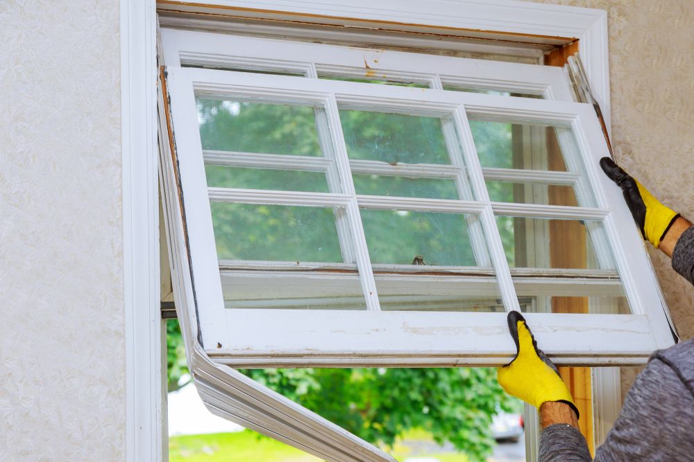 worker removing an old wooden window