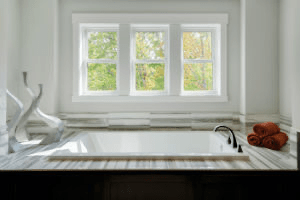 bathtub with three windows above it