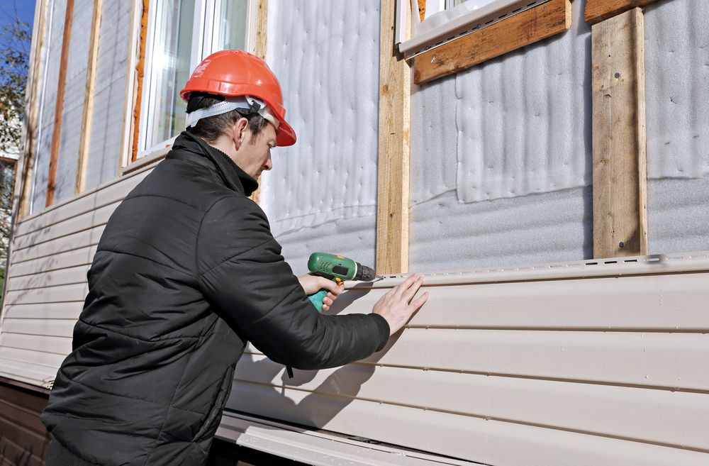 Contractor installing vinyl siding