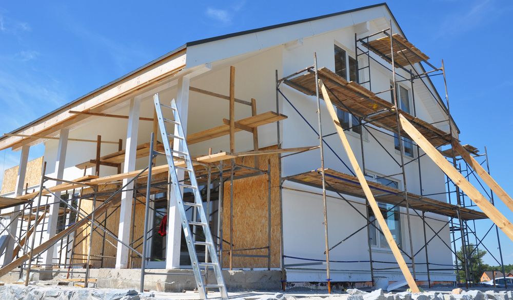 Home exterior renovation in progress with siding and openings exposed