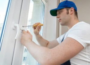 Professional handyman fixing window handle at home