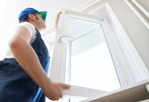 Professional handyman installing window at home